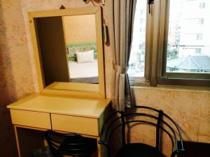 uno specchio posto sopra una scrivania con sedia di Kai Cheng Inn 旅館134 a Jiaoxi