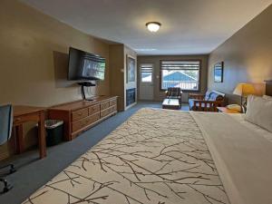 1 dormitorio grande con 1 cama grande y TV en The Grand Tappattoo Resort, Ascend Hotel Collection en Otter Lake