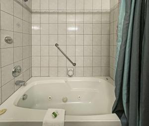 y baño alicatado con bañera blanca. en The Grand Tappattoo Resort, Ascend Hotel Collection en Otter Lake