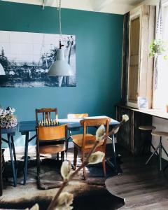 uma sala de jantar com uma parede azul e uma mesa e cadeiras em Bed & Breakfast [H]eerlijk! em De Kwakel