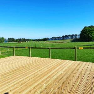 a wooden deck with a view of a field at Birchlea Caravan in Stonehaven