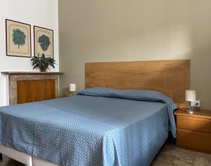 um quarto com uma cama com um cobertor azul em Albergo Della Torre em Cernobbio