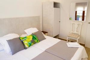 a bedroom with a white bed and a chair at vallespin 43 parking, wifi in Ávila