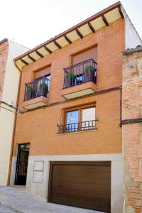 a brick building with a garage and two balconies at vallespin 43 parking, wifi in Avila