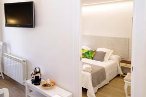 a bedroom with a bed and a tv on a wall at vallespin 43 parking, wifi in Avila