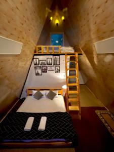 Woodzo Shangarh في Sainj: غرفة نوم مع سرير بطابقين وسلم