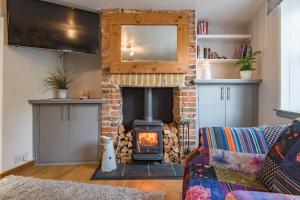 a living room with a fireplace and a couch at Cow and Cockle - quirky cottage in the centre of Deal in Deal