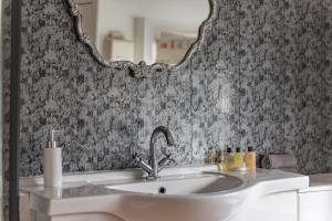 a bathroom with a sink and a mirror at Cow and Cockle - quirky cottage in the centre of Deal in Deal