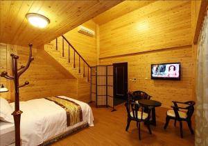 a bedroom with a bed and a tv in a room at Zhuyuan Ju B&B in Yuanshan