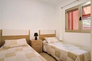 1 dormitorio con 2 camas y ventana en Ca Luis, en Mogán
