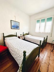 2 camas en un dormitorio con suelo y ventanas de madera en A Casa di Paola en Adria