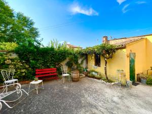 a patio with a red bench and chairs in front of a building at A Casa di Paola in Adria