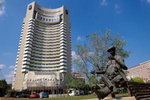 a large building with a statue in front of it at Grand Hotel Bucharest in Bucharest