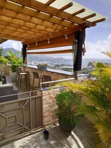 une terrasse avec une pergola, une table et des chaises dans l'établissement 180 Degrees Self-Catering, à Victoria