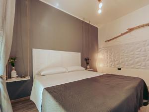 a bedroom with a large bed with a white headboard at Il Ritrovo di Ulisse in Villa San Giovanni