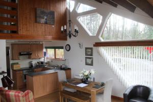 a kitchen with a wooden table and a window at Invergloy Riverside Lodges in Spean Bridge