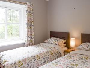 2 camas individuales en una habitación con ventana en The Barn, en Fintry