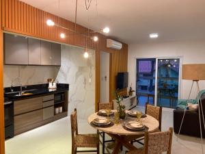 a kitchen and dining room with a table and chairs at Apartamento a 100 metros da praia no melhor bairro de Bertioga in Bertioga