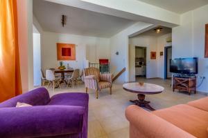 a living room with purple couches and a tv at Istron Collection Villas in Istron