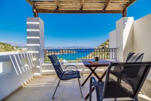 a balcony with a table and chairs and a view of the ocean at Istron Collection Villas in Istron