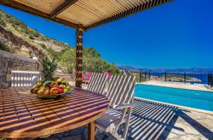 a table with a bowl of fruit on top of a patio at Istron Collection Villas in Istron