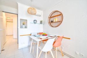 uma cozinha e sala de jantar com uma mesa branca e cadeiras em Résidence La Palme d'Azur - Cannes em Cannes