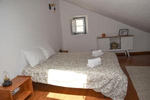 a bedroom with a large bed and a table at Casa das Gémeas - Moradia rústica in Castelo de Vide