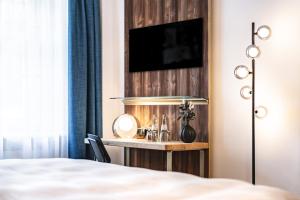 a bedroom with a desk with a television on a wall at Blauer Bock in Passau