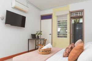a bedroom with a bed with a tv on the wall at Casa de Pinos Hotel Boutique in Bucaramanga