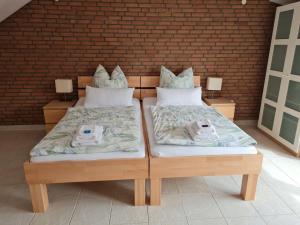 two twin beds sitting next to a brick wall at Pension Wendler in Bedburg