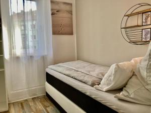 a bed in a room with a window at Living at Saarpartments -Adults Only- 2 Bedrooms, Netflix - Business & Holiday Apartments for Long- and Short term Stay, 3 min to Train Station and Europa Galerie in Saarbrücken