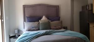a bedroom with a bed with blue sheets and pillows at The Moore Guesthouse in Pretoria