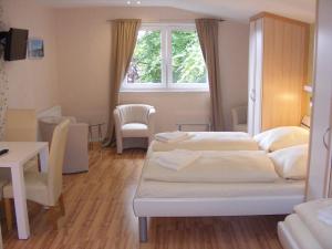 Habitación de hotel con 2 camas, mesa y sillas en Landgasthof Tarp en Tarp