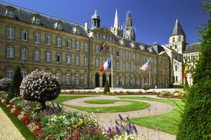 a large building with a garden in front of it at Mercure Caen Centre Port De Plaisance in Caen