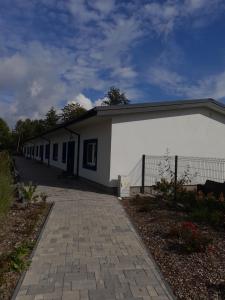 a small white building with a fence next to it at Szafir - NoclegiGrodziskPL in Grodzisk Mazowiecki