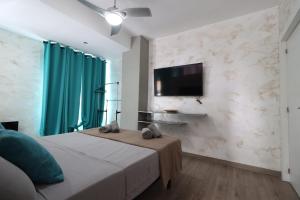 um quarto com uma cama e uma televisão de ecrã plano em Carthago Suites em Cartagena