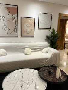 a bedroom with a large bed with paintings on the wall at Superbe Appartement kantaoui sousse in Sousse