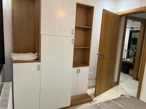 Superbe Appartement kantaoui sousse في سوسة: غرفة بها ثلاجة بيضاء وخزانة