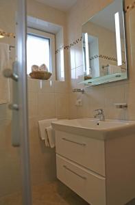 a bathroom with a sink and a mirror at Zeilner Dachstein Apartment in Gosau