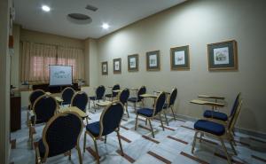 una habitación con mesas, sillas y una pantalla en Hotel Regio 2, en Cádiz