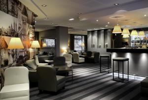 a hotel lobby with couches and a bar at Mercure Caen Centre Port De Plaisance in Caen