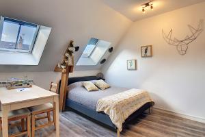 a bedroom with a bed and a desk and windows at Studio'Moment Saint-Omer Centre in Saint-Omer