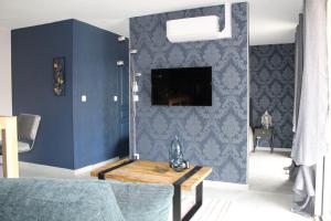 a living room with blue walls and a table at Althéa, gîte de charme et bien être in Fontenay-le-Comte