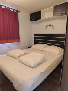 łóżko z dwiema poduszkami w pokoju w obiekcie Mobile home 6-pers Camping Leï Suves-Côtes d'Azur-including airco w mieście Roquebrune-sur Argens +23 zdjęcia