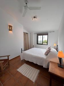 a white bedroom with a bed and a window at Padre Aviles in Olías