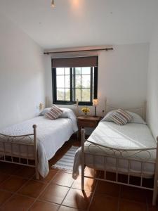 two beds in a room with a window at Padre Aviles in Olías