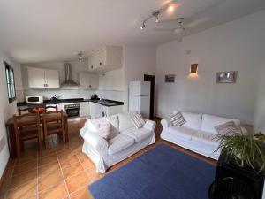 a living room with two white couches and a kitchen at Padre Aviles in Olías