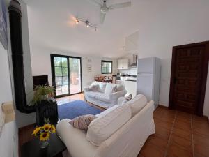 a living room with two white couches and a kitchen at Padre Aviles in Olías