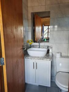 a bathroom with a sink and a toilet at Chalés Rota das Cachoeiras in Urupema