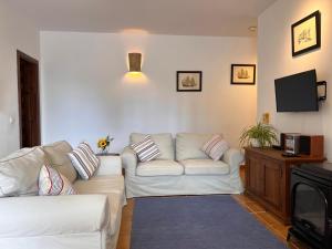 a living room with two white couches and a tv at Padre Aviles in Olías
